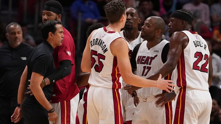 Miami Heat head coach Erik Spoelstra is held back as strong words are exchanged on the Miami Heat bench