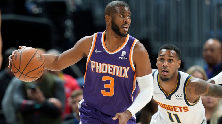 Phoenix Suns guard Chris Paul, left, dsrives past Denver Nuggets guard Monte Morris in the first half of an NBA basketball game Thursday, March 24, 2022, in Denver. (AP Photo/David Zalubowski)...............